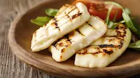 Halloumi on a wooden plate with a rustic background